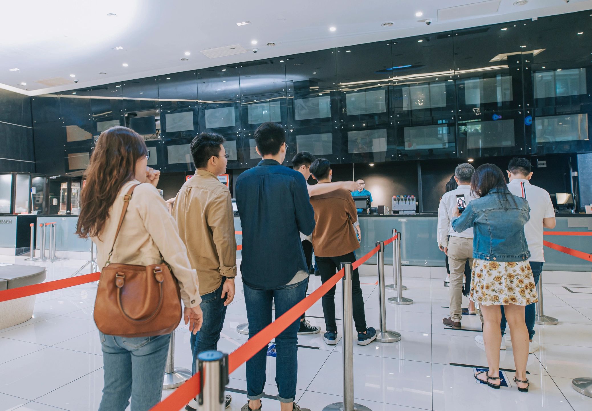 Guests waiting in line at a ticket counter representing access control and screening